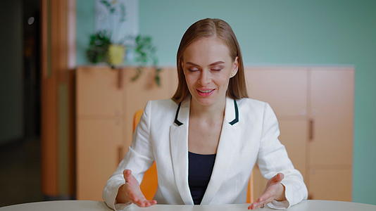 一位成功的女商人坐在一间明亮的现代办公室里用相机说话视频的预览图