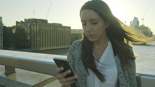 有吸引力的女性商家使用智能手机通勤视频的预览图