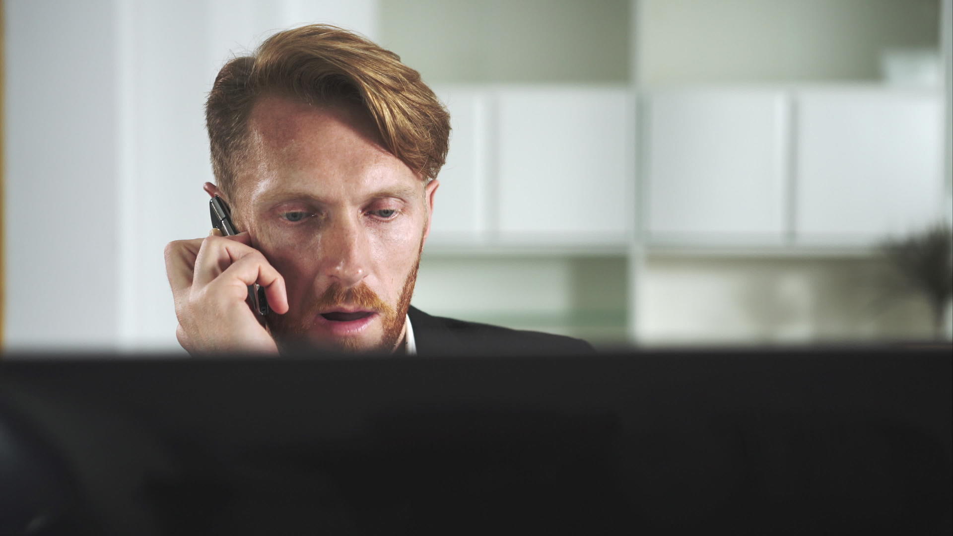 红头发人坐在电脑前打电话视频的预览图