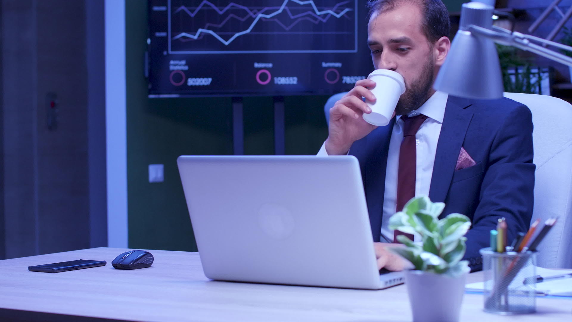 疲惫的商人在笔记本电脑工作时喝咖啡视频的预览图