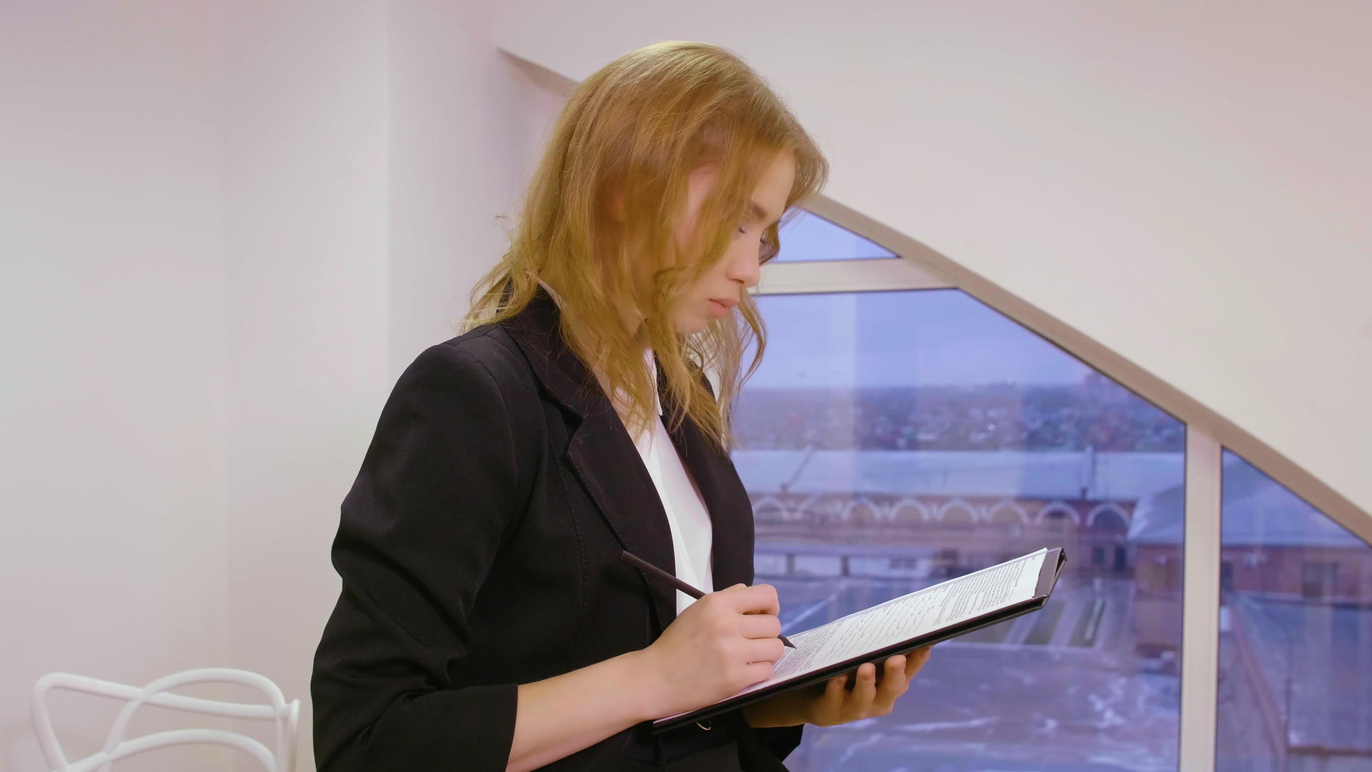 妇女商业企业家与办公室的文件和文件一起工作的窗口背景视频的预览图