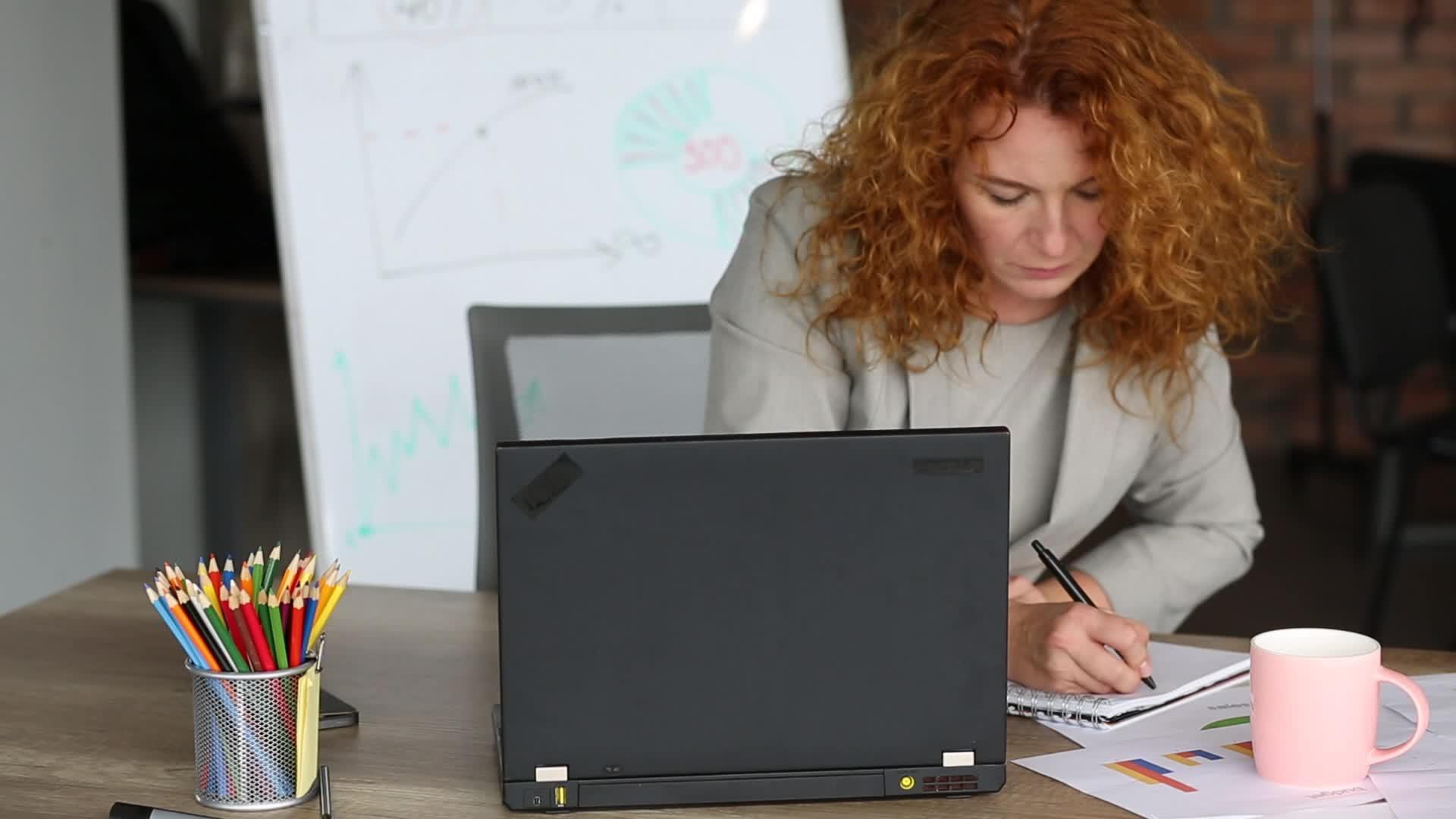 在办公室工作的有压力的红发女性视频的预览图