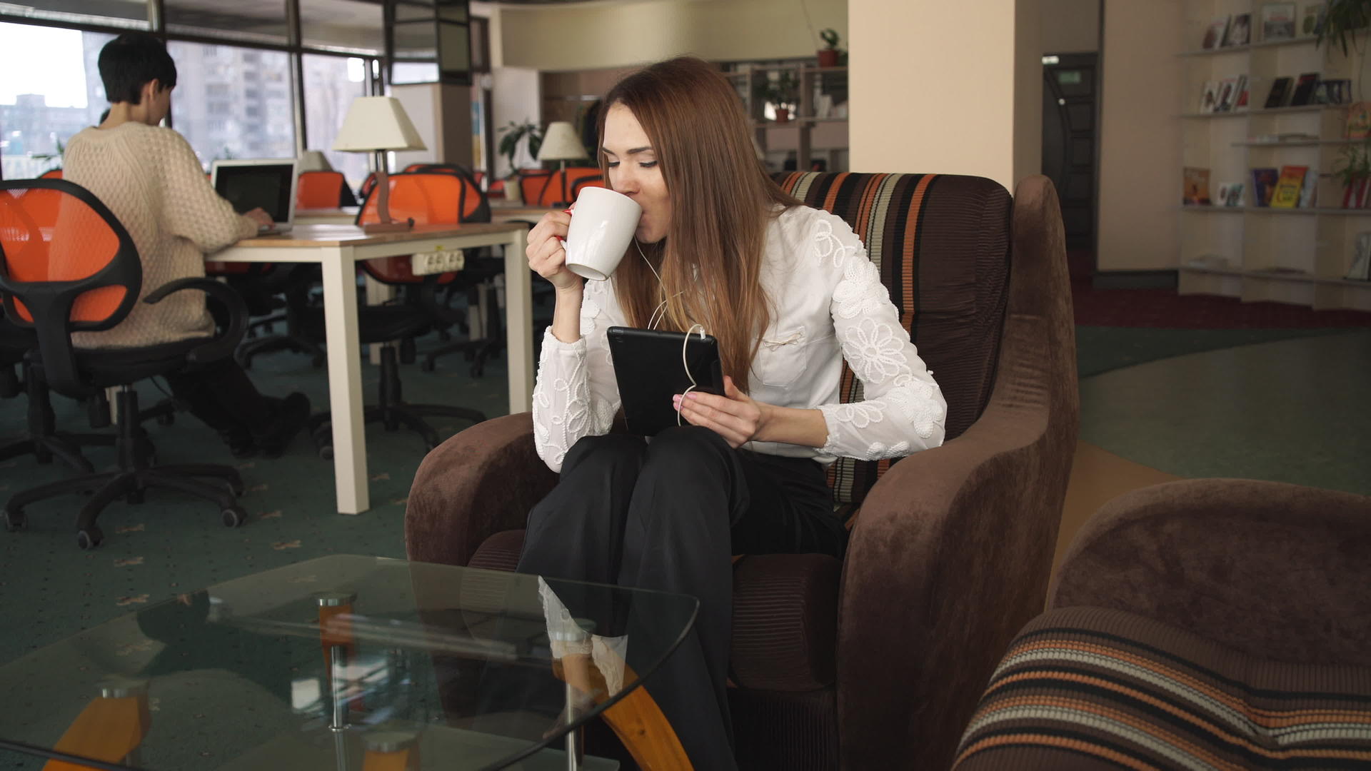 年轻女性在触摸屏上说话和喝咖啡视频的预览图