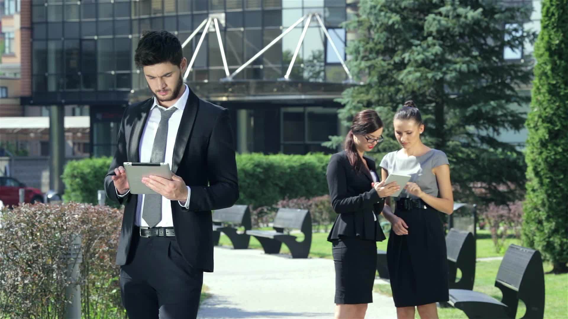 三个商人在街上说话是平板电脑的原因视频的预览图