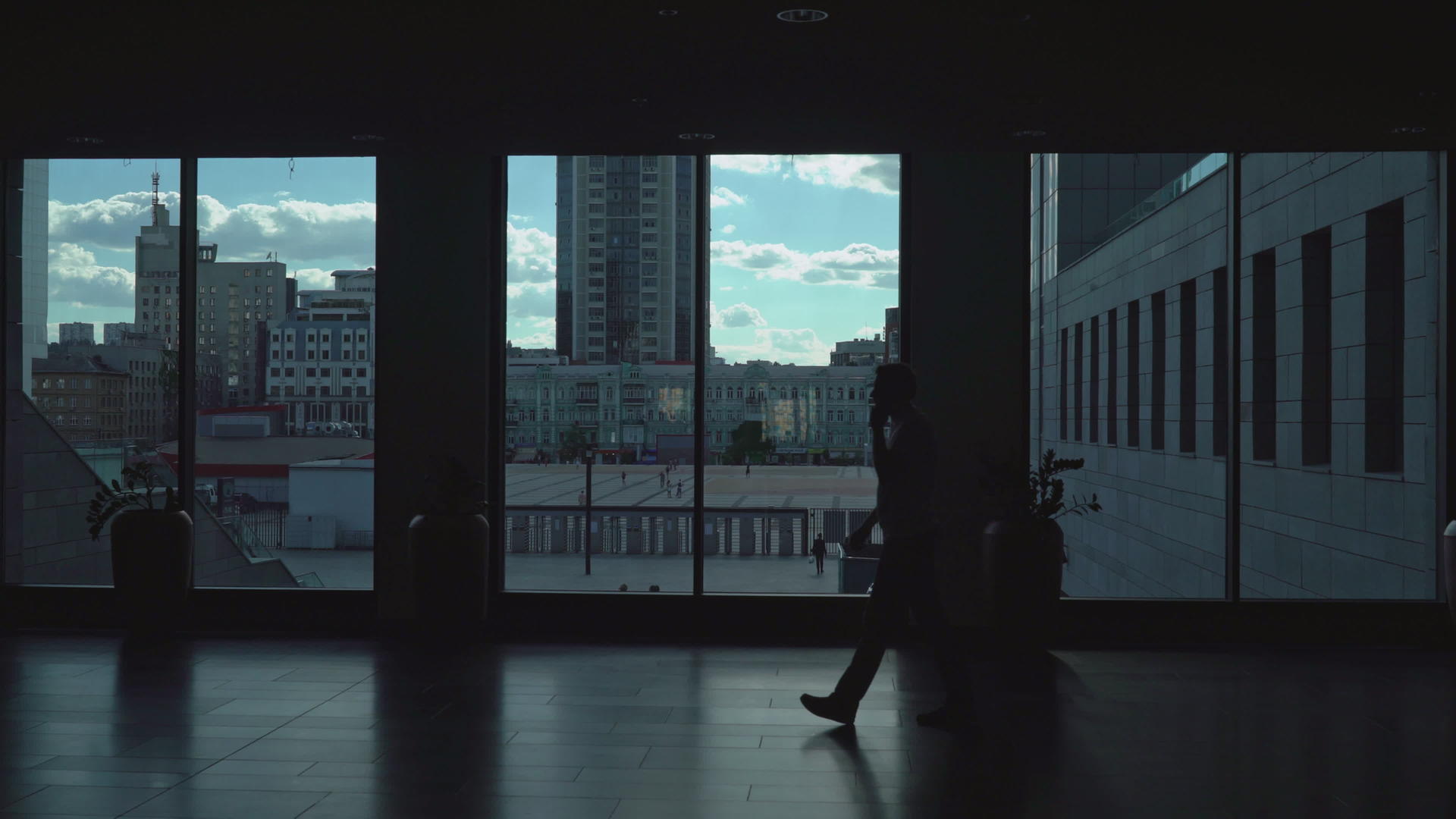 男人走在有大窗户的黑暗走廊里视频的预览图