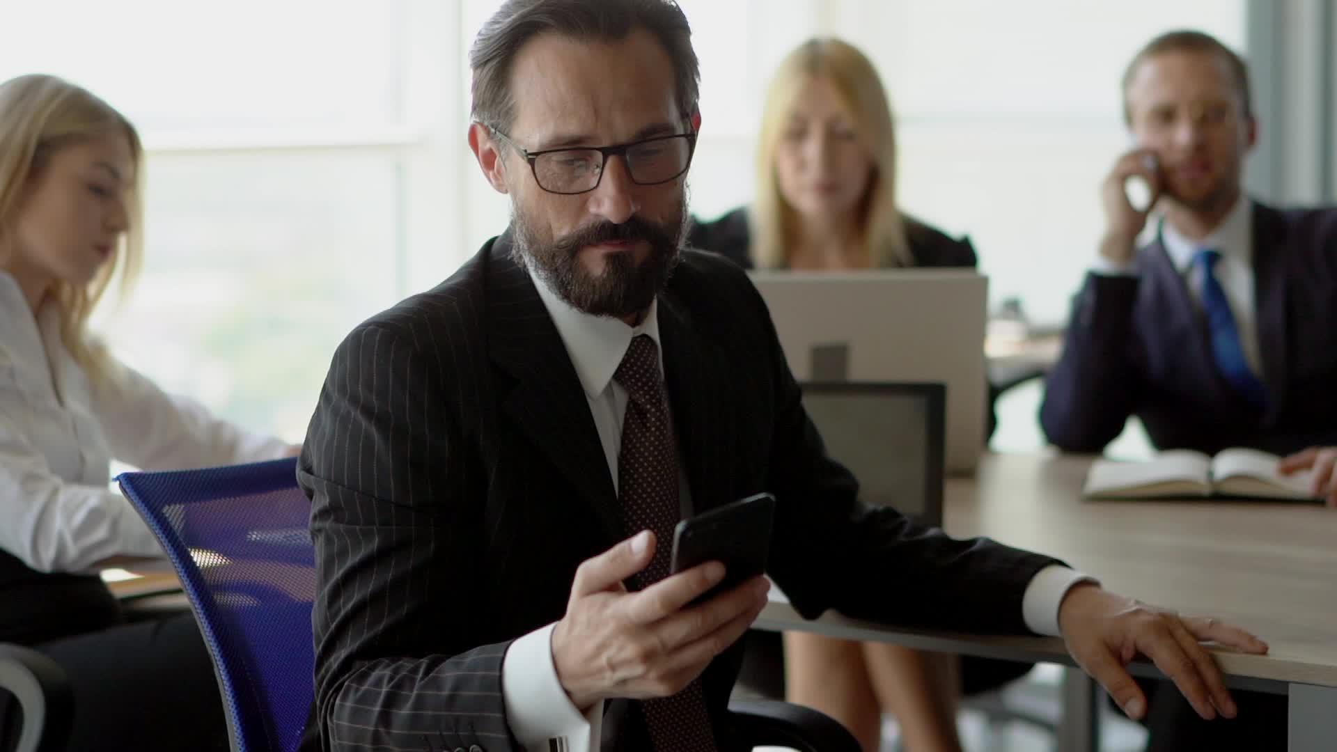 领导商业团队的领导用手机对着镜头微笑视频的预览图