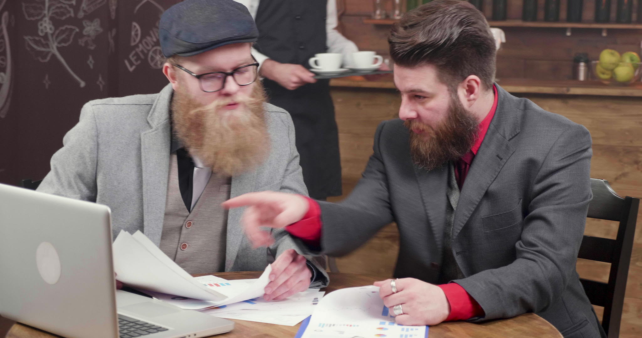 长胡子英俊的大胡子自由职业者喝咖啡分析新的投资可能性视频的预览图