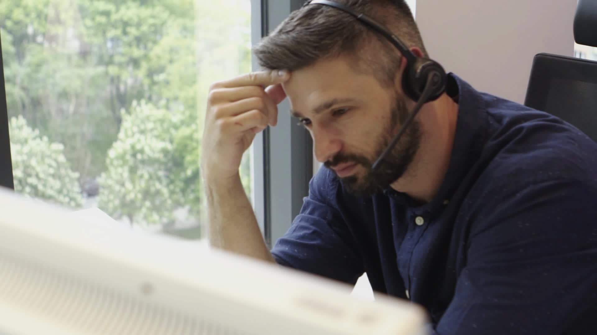 在呼叫中心办公室使用耳机工作的有色胡子吸引商人视频的预览图
