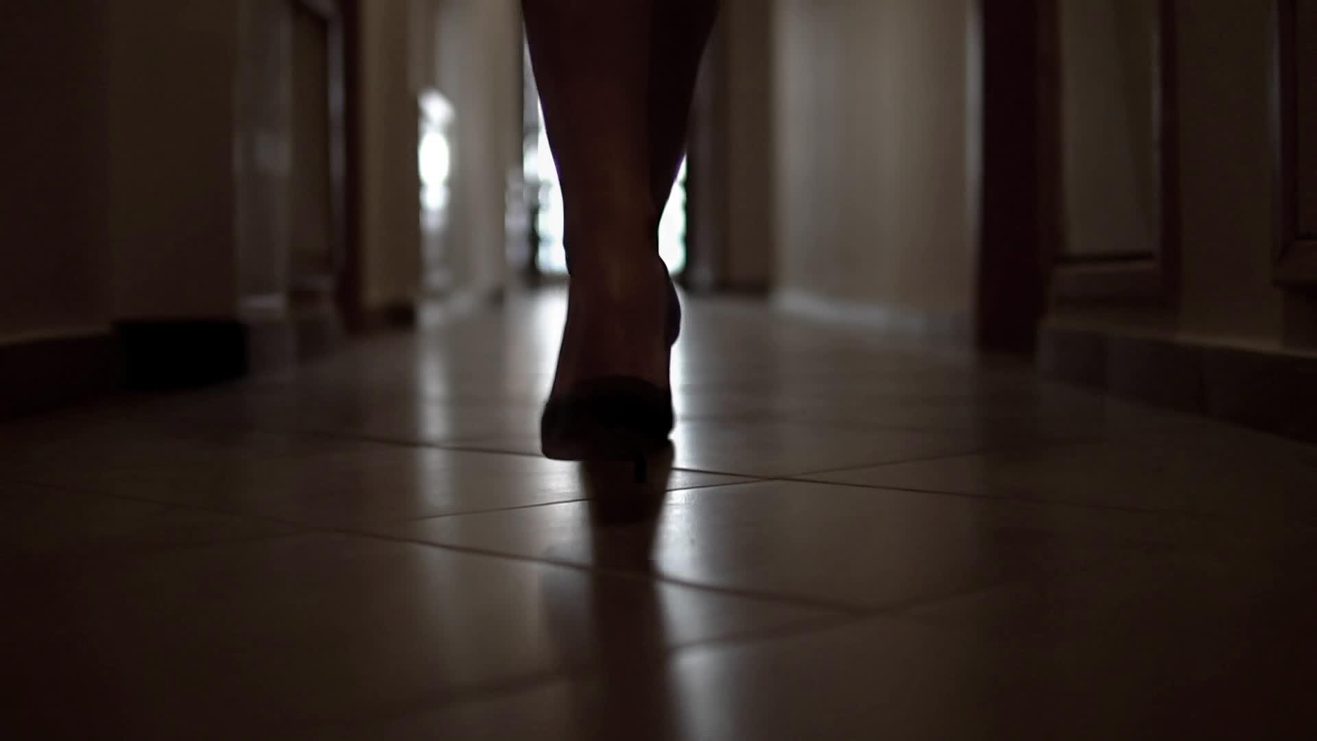 多莉和低腿的剪影女商人穿着高山鞋在走廊里慢慢走视频的预览图