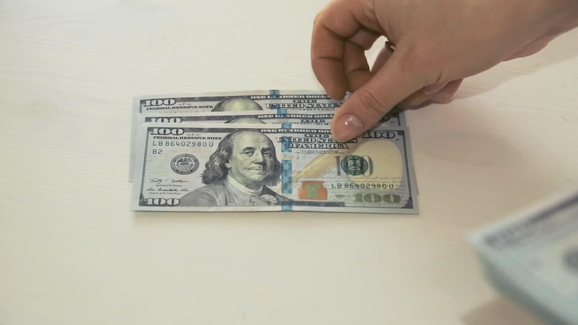 女人的手在白色背景上数钱视频的预览图