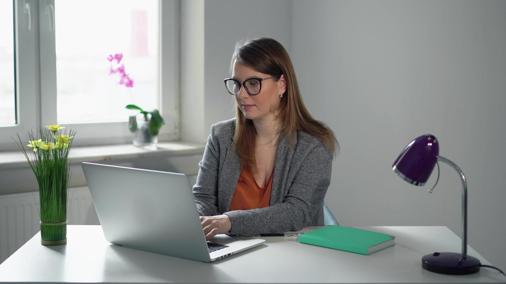 一个在办公室用笔记本电脑工作的年轻女经理视频的预览图