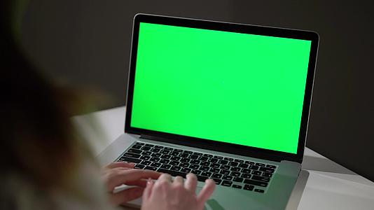 女性使用绿色屏幕染色体工作或使用笔记本电脑视频的预览图