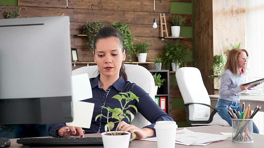 年轻的商业女性在办公室从事计算机工作视频的预览图