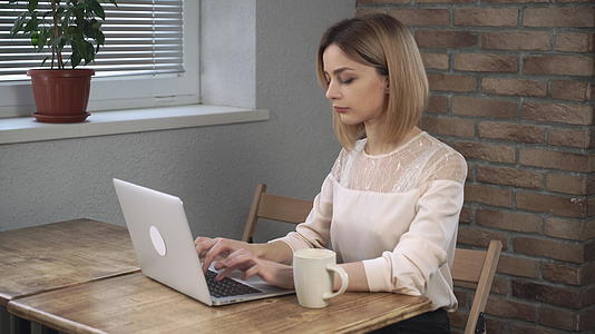 女性使用笔记本电脑和打手咖啡视频的预览图
