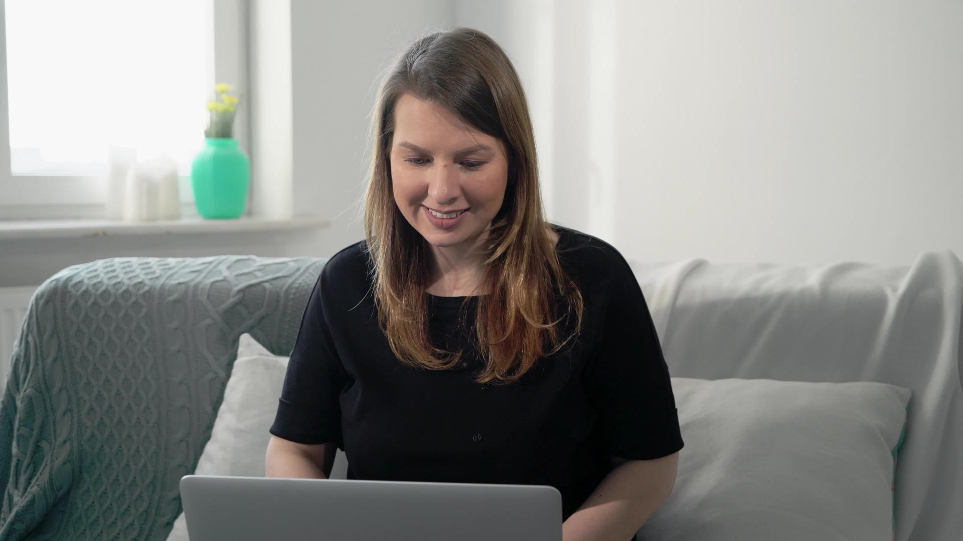 在家远程使用电脑和笔记本电脑的年轻女性视频的预览图