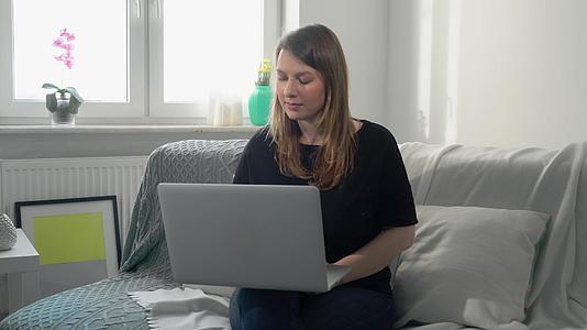 在家远程使用电脑和笔记本电脑的年轻女性视频的预览图