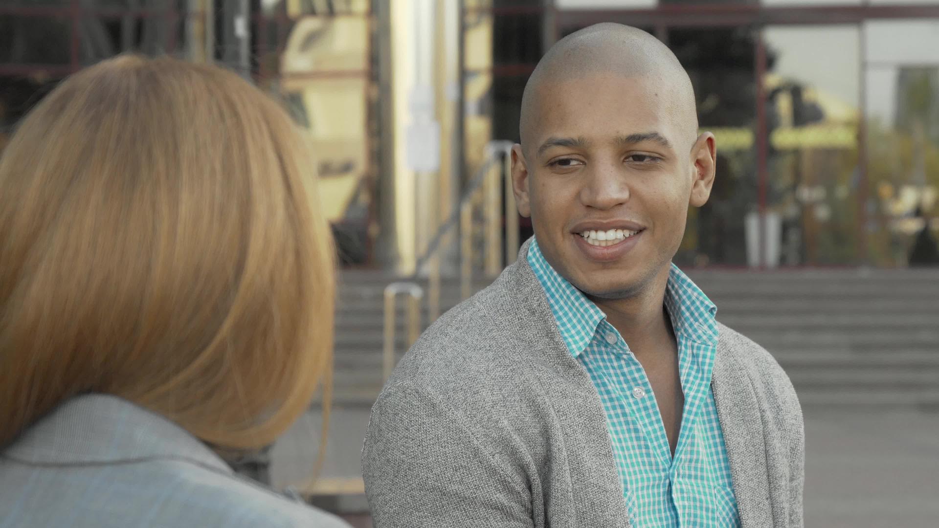英俊、英俊、快乐的非洲美国人在户外与朋友聊天视频的预览图