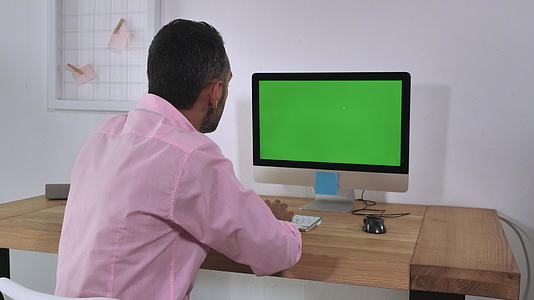 一个在室内使用电脑的不可辨认的男人视频的预览图
