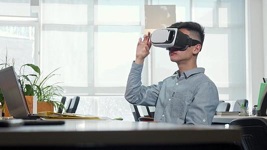 年轻商人在工作时使用3DVR眼镜视频的预览图