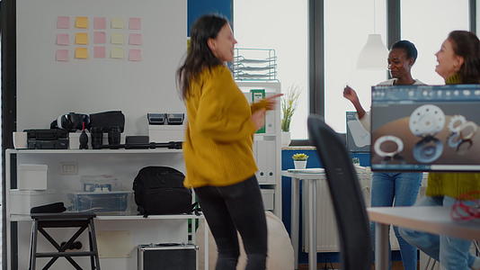 快乐多元的女性在公司办公室成功跳舞庆祝项目视频的预览图