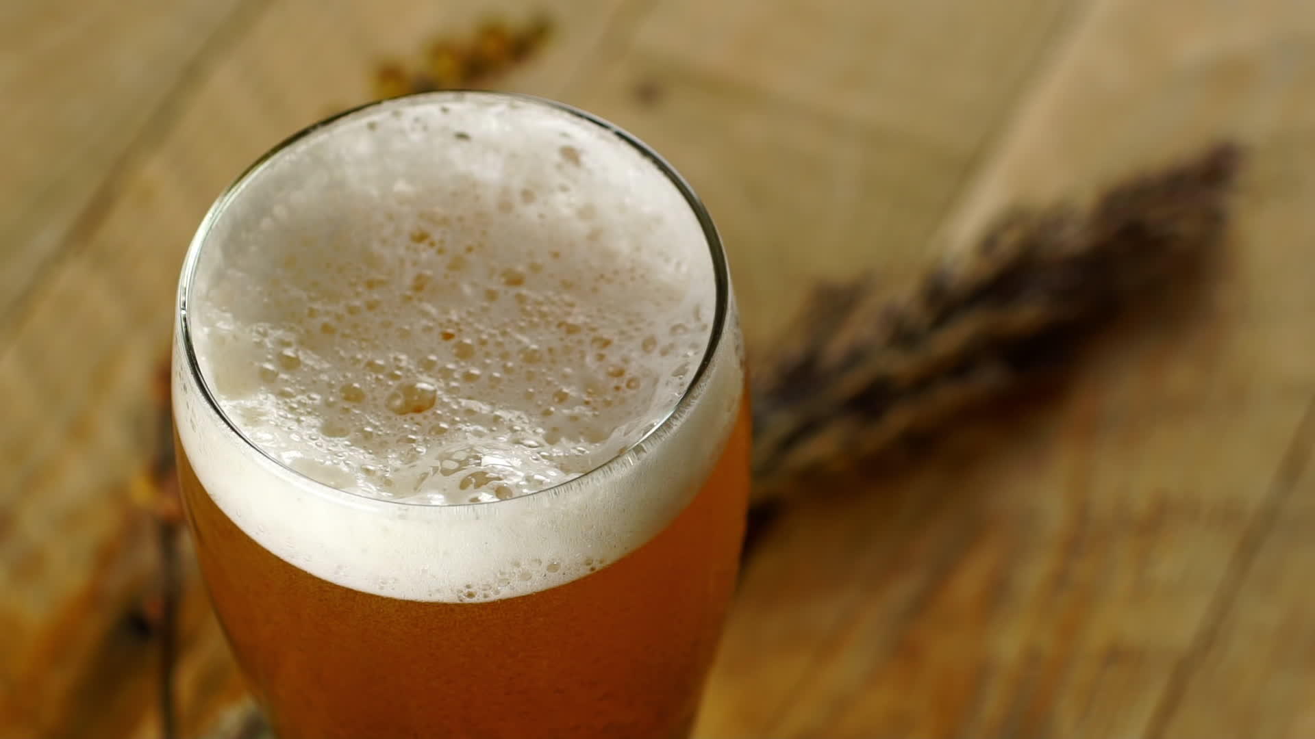 把啤酒倒在木桌上的玻璃杯里视频的预览图
