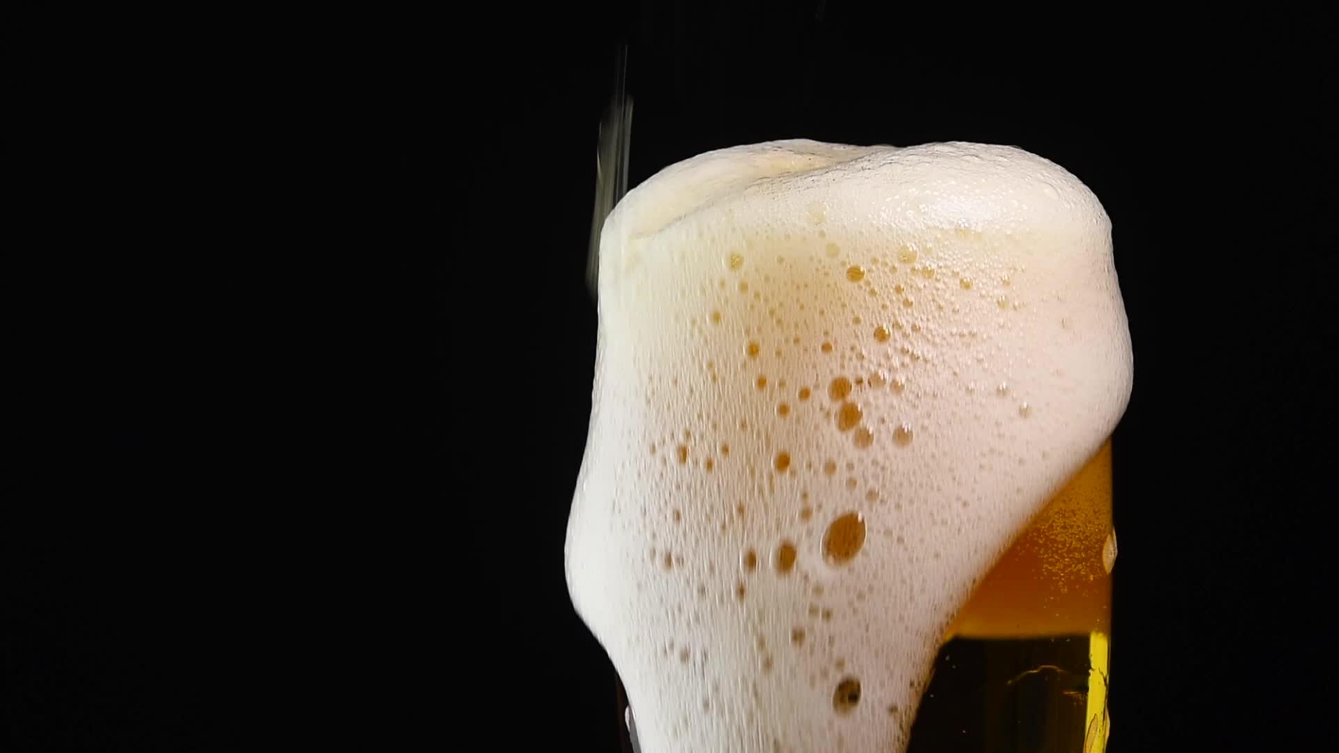 把啤酒倒得紧紧的在玻璃杯子里加黑视频的预览图
