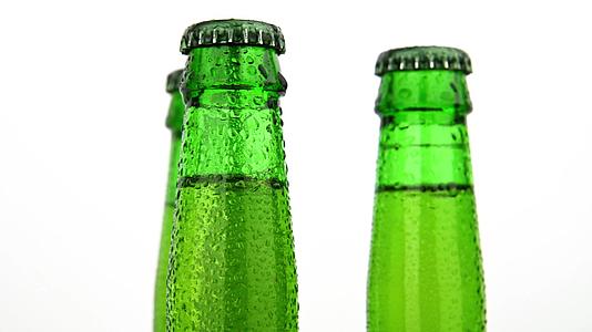 三个绿色啤酒瓶在白色上旋转视频的预览图