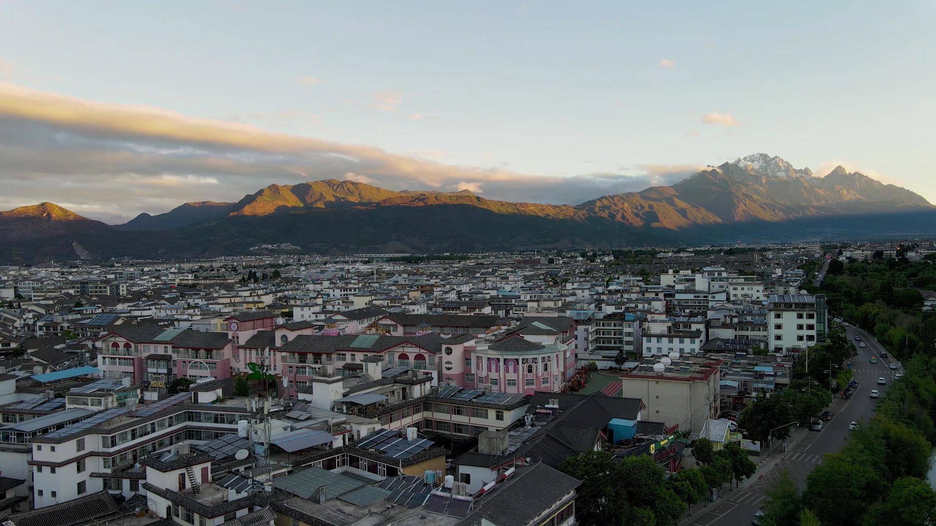 航拍清晨的丽江市区和远眺玉龙雪山视频的预览图