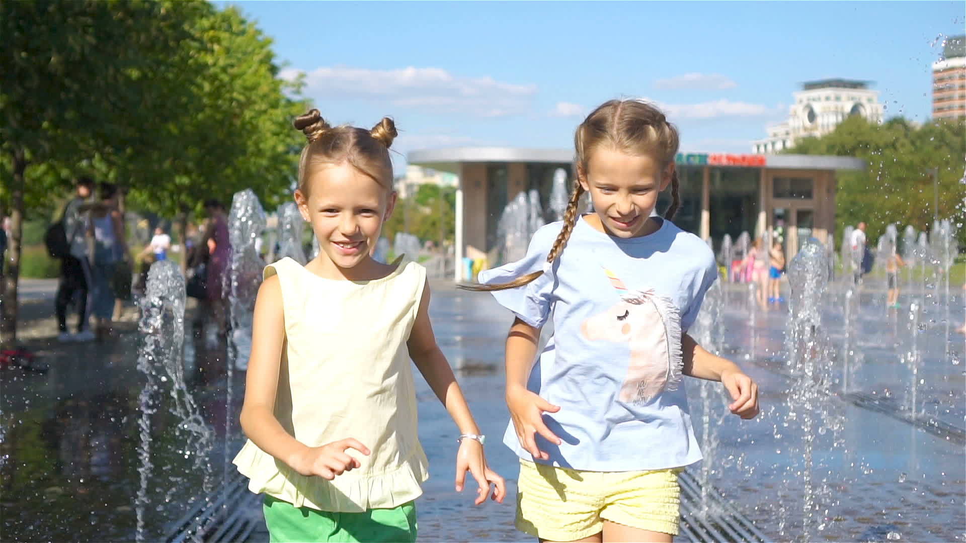 可爱的小女孩们在阳光明媚的日子里在街头喷泉里玩得很开心视频的预览图
