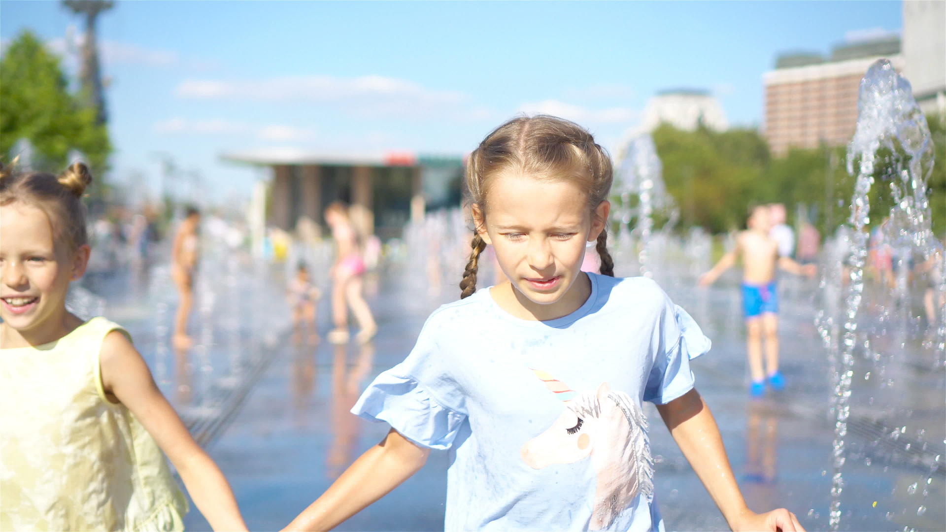 可爱的小女孩们在阳光明媚的日子里在街头喷泉里玩得很开心视频的预览图