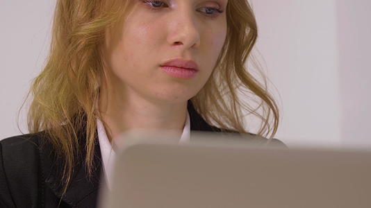 在笔记本电脑上工作的有魅力的女商人近距离关闭视频的预览图