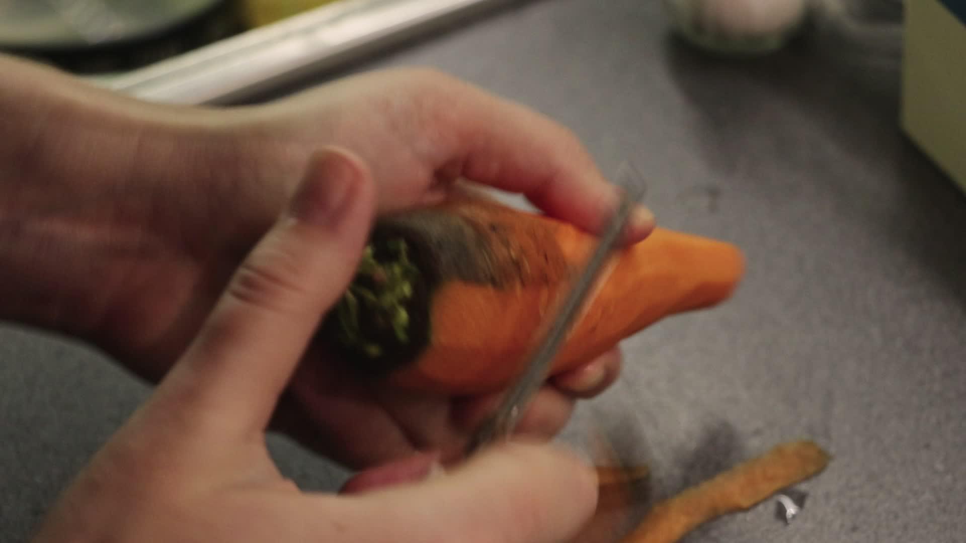 在厨房里剥胡萝卜的女人视频的预览图