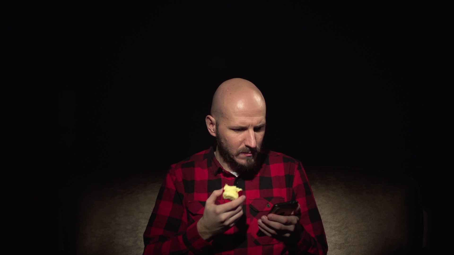 有胡子吃苹果的年轻年轻秃头长发男子视频的预览图