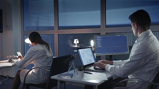 一个穿着白大褂的电子工程师团队在高级实验室的计算机上工作视频的预览图