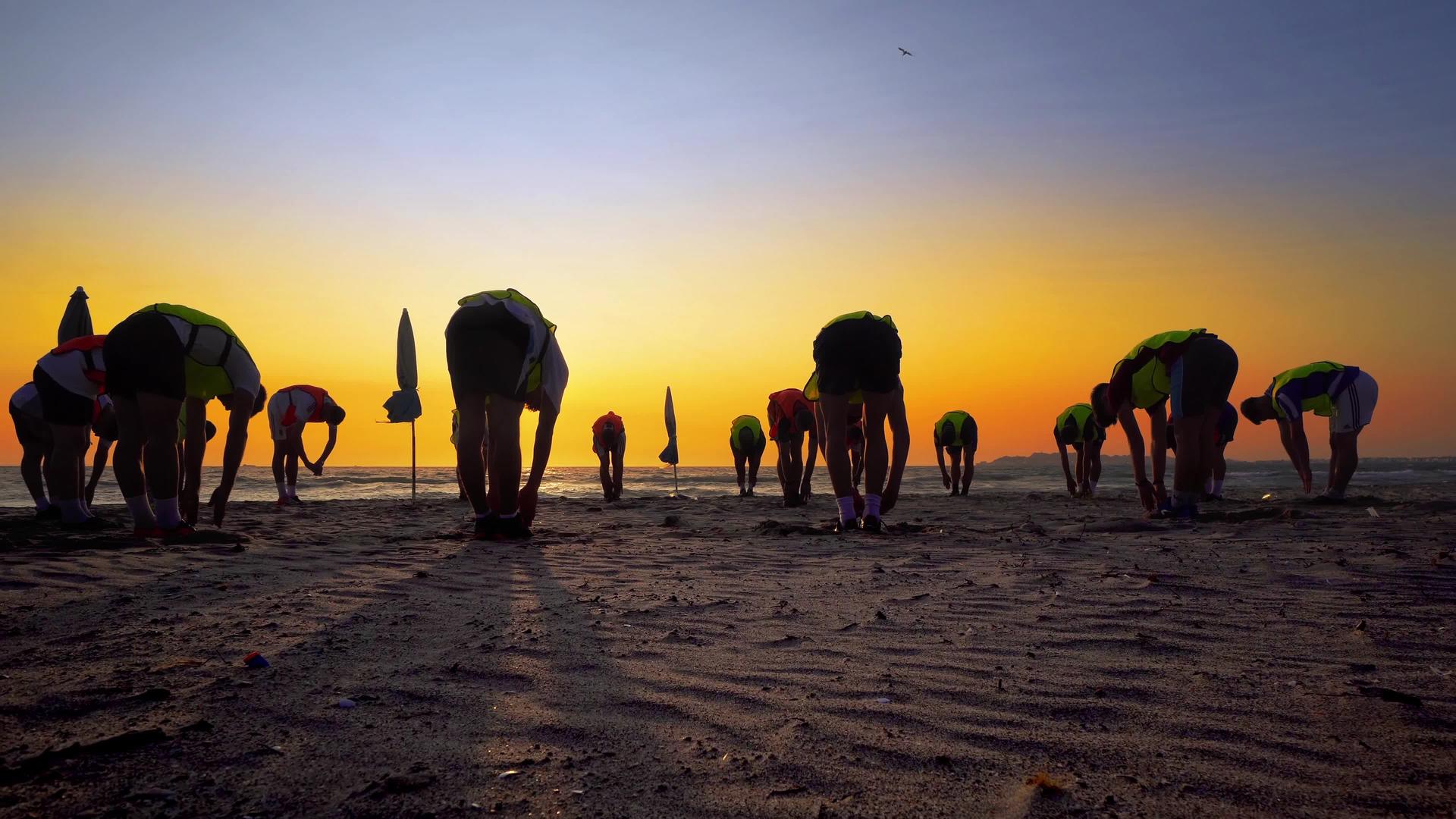 在日落的海滩上训练男孩的足球队Standicam视频的预览图