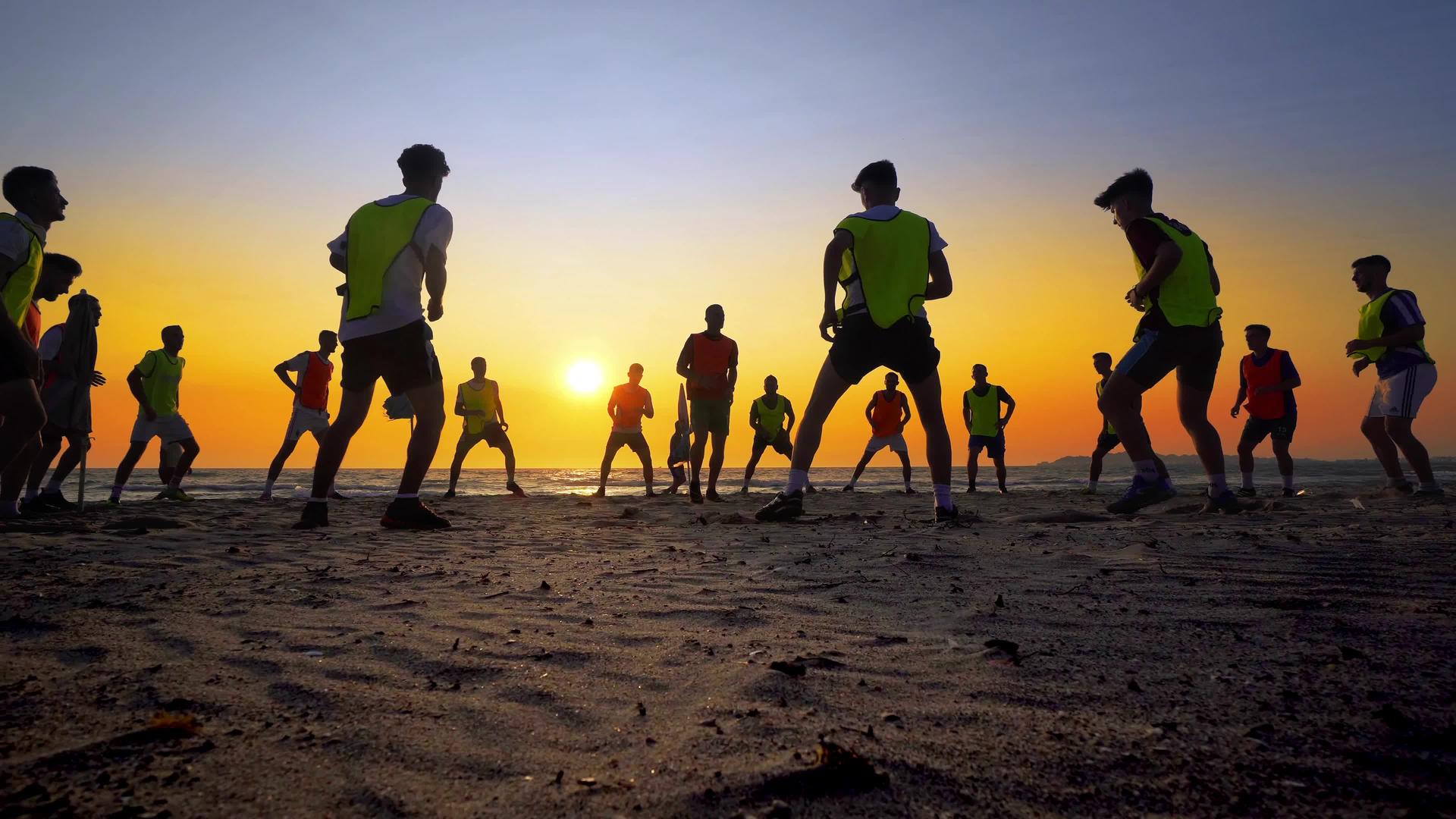 在日落的海滩上训练男孩的足球队Standicam视频的预览图