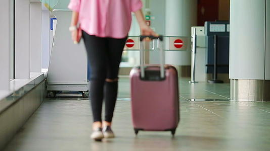 在机场休息室使用护照、登机牌和粉色行李视频的预览图