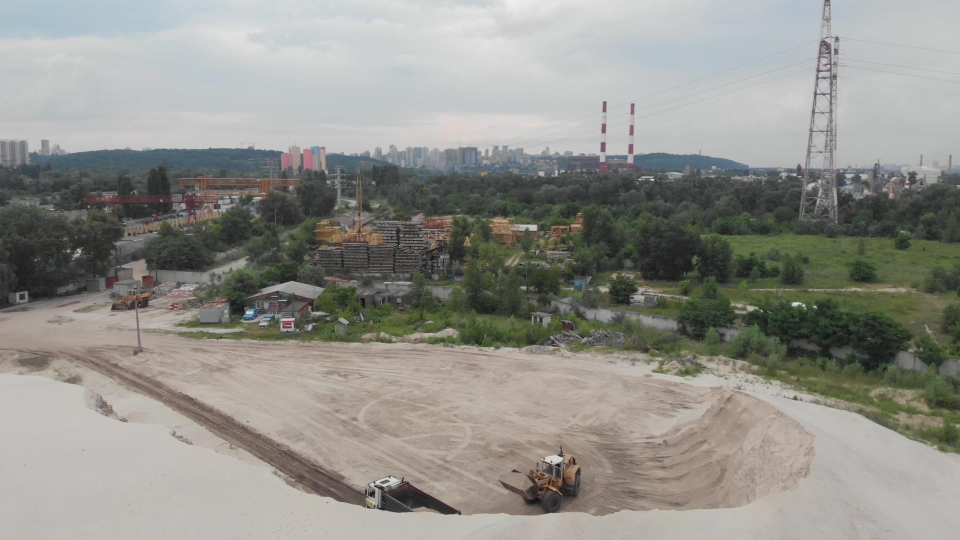挖掘机将沙子装入乌克兰基辅工业区的大量沙场视频的预览图