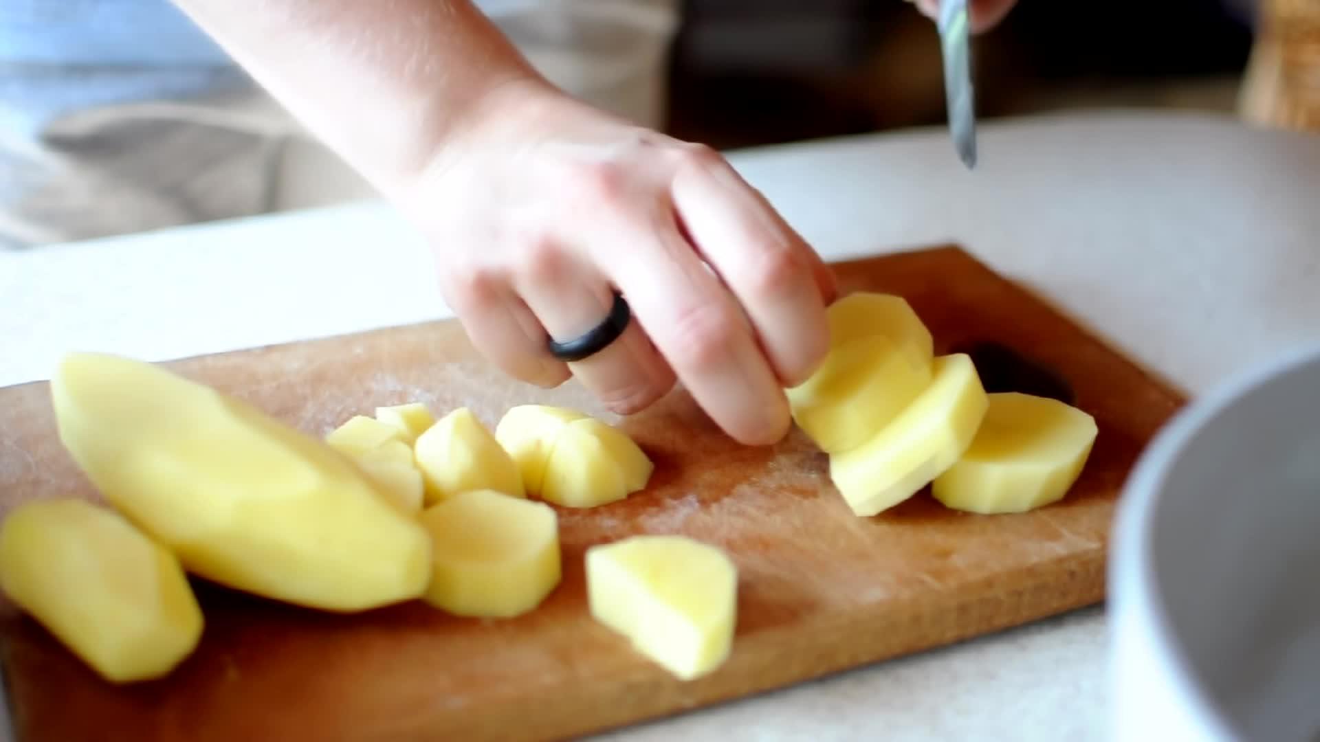 厨师用锋利的刀在木剪板上切土豆视频的预览图