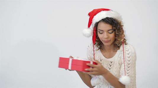 美丽的女孩摇晃着圣诞礼物视频的预览图