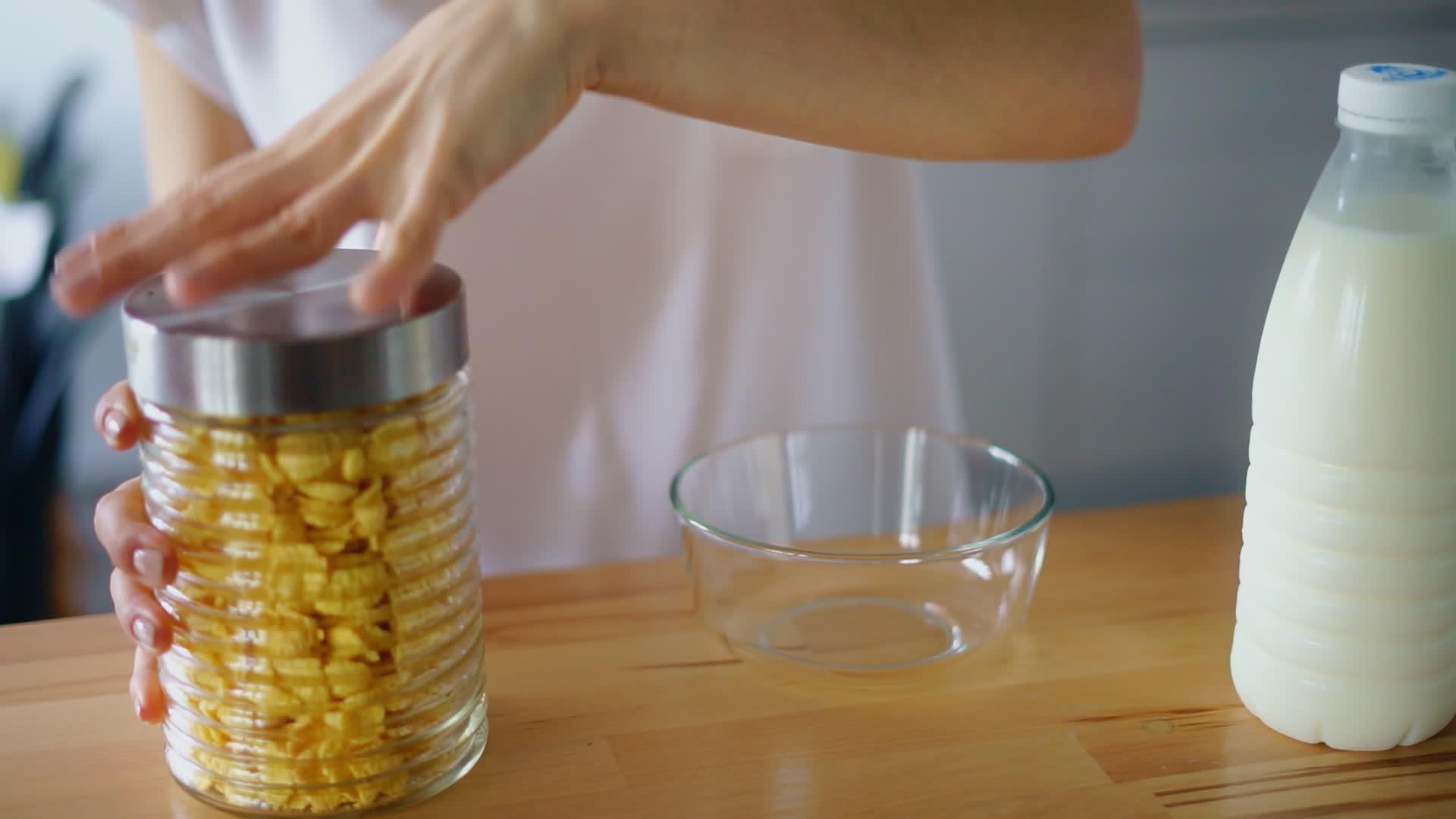 女子打开罐子将玉米片倒入玻璃碗中视频的预览图