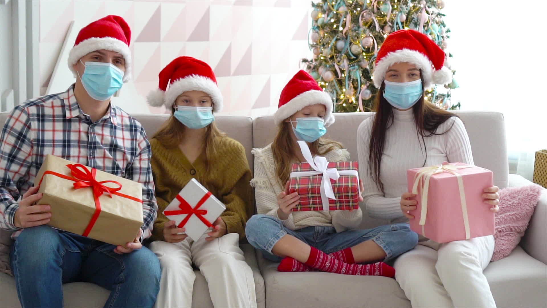 四口之家在圣诞节戴着口罩和礼物视频的预览图
