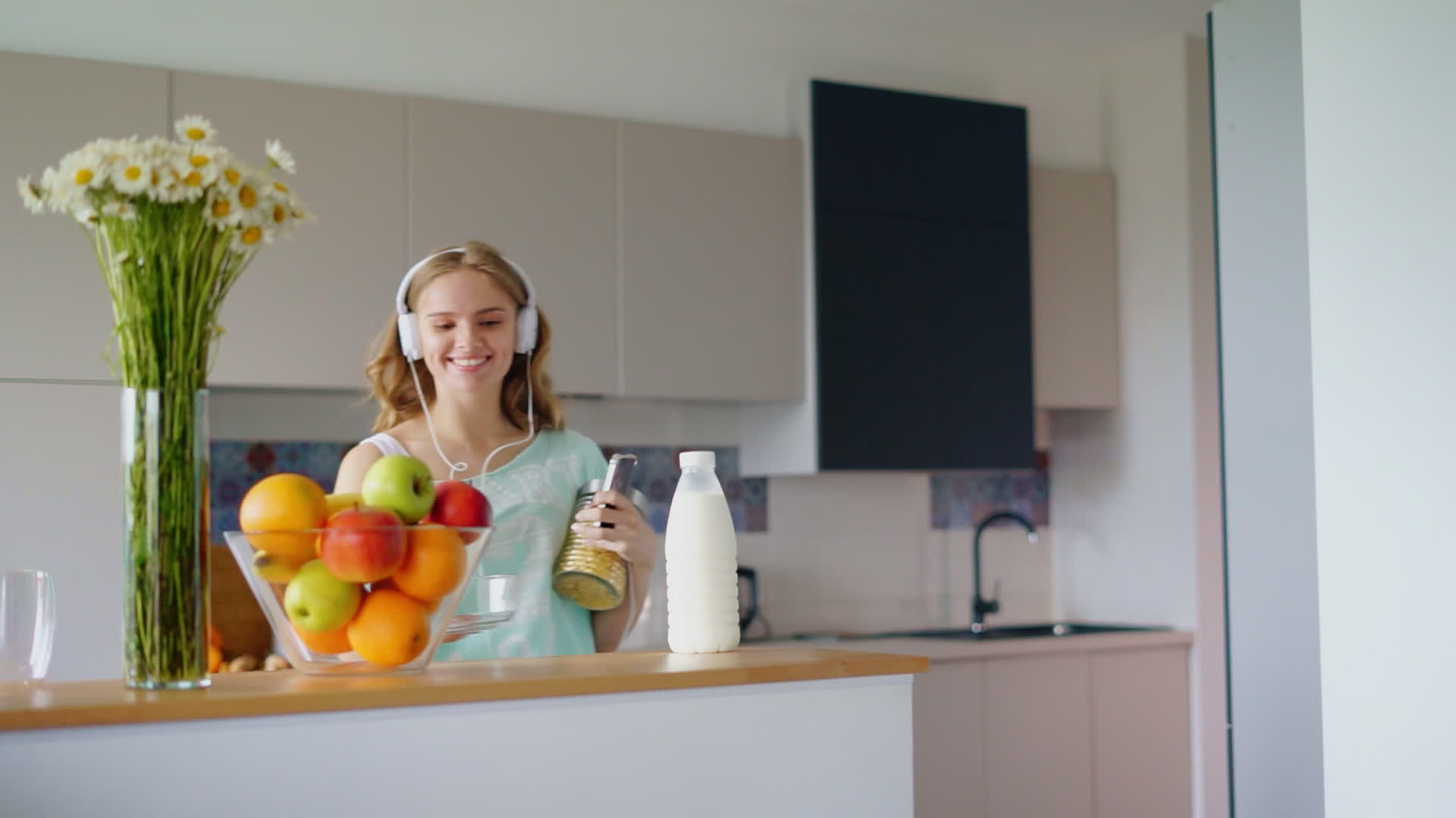 快乐快乐的女人快乐的孩子在厨房里用智能手机听音乐视频的预览图