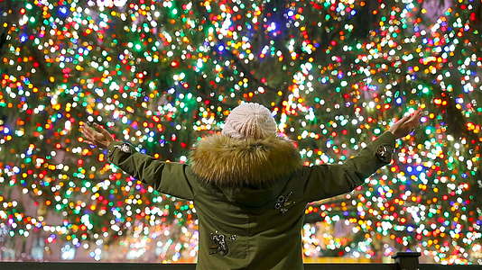 洛克菲勒中心是一个快乐的女孩在纽约洛克菲勒圣诞树的背景下洛克菲勒中心美丽视频的预览图