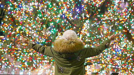 快乐女孩在纽约洛克菲勒圣诞树的背景下视频的预览图
