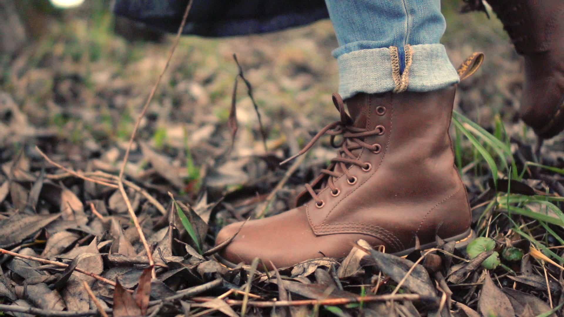 一只穿着棕色鞋子的脚在森林里枯叶草地上视频的预览图