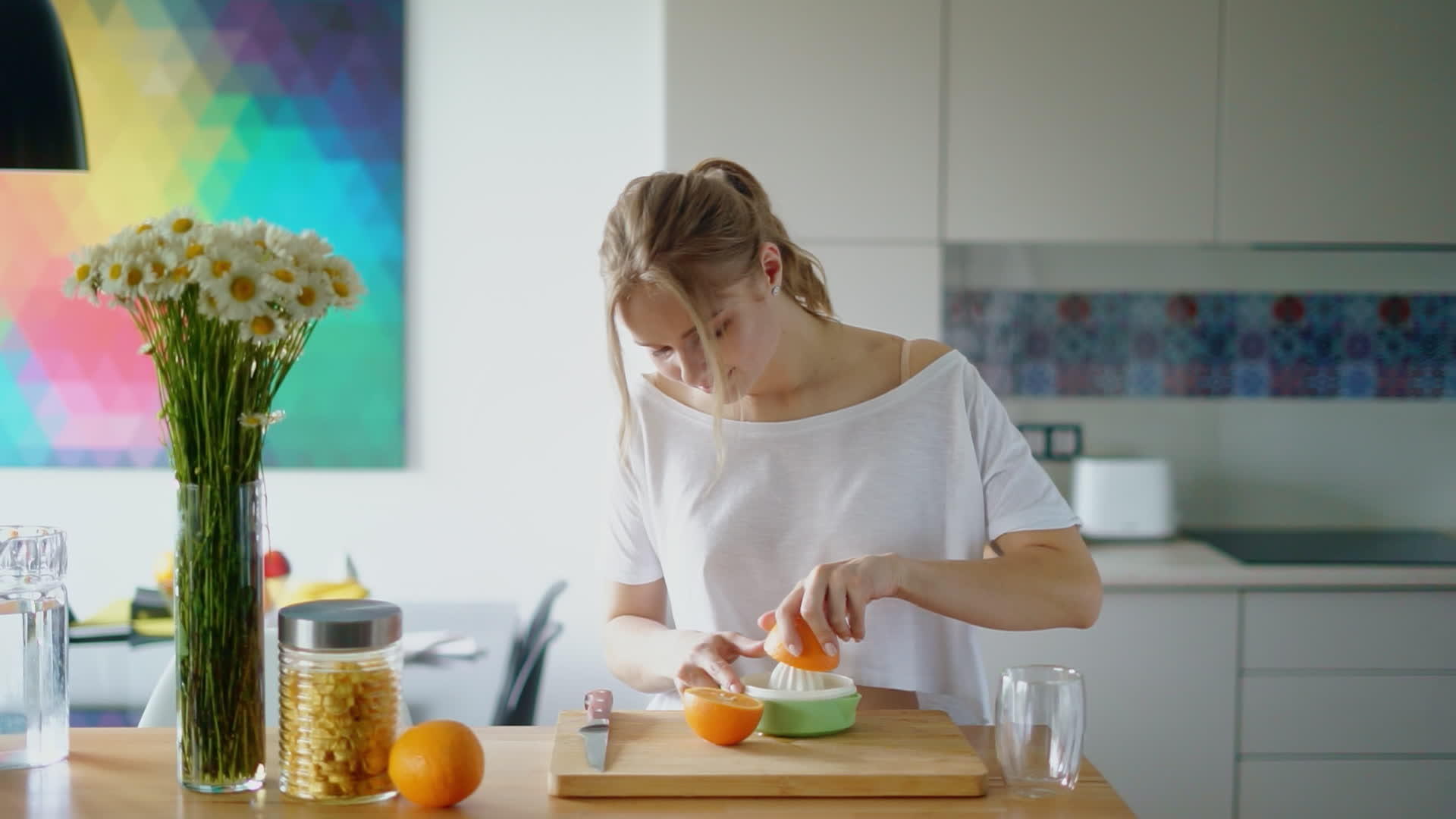 年轻女子用柑橘汁挤压鲜橙视频的预览图