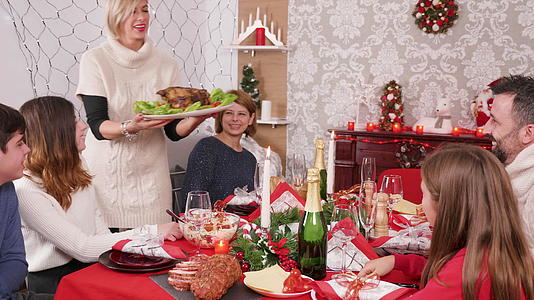 在圣诞晚餐上女人们带着美味的火鸡来了视频的预览图