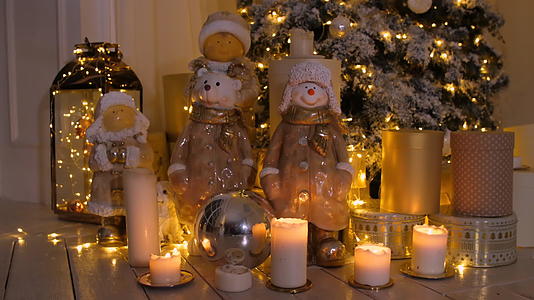 在舒适的客厅里发光的圣诞树蜡烛装饰和花园视频的预览图