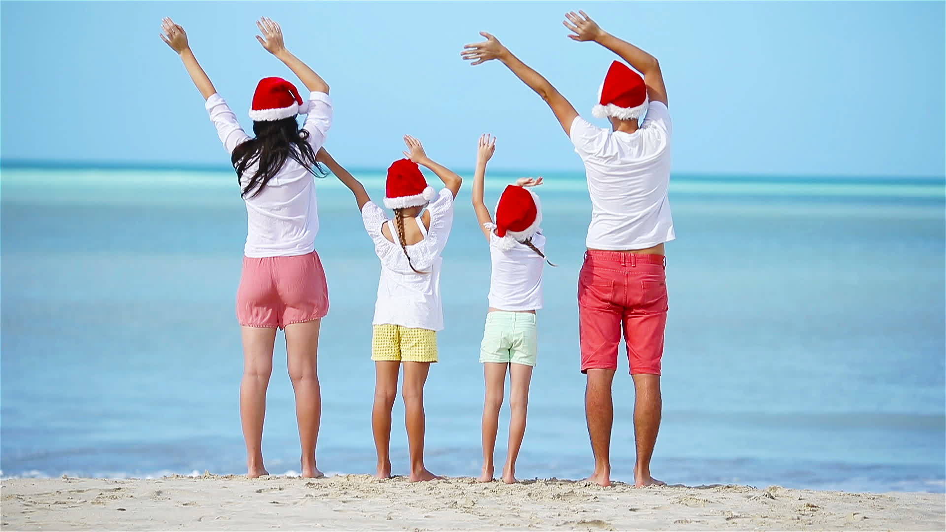 一家人在海边戴着圣诞帽视频的预览图
